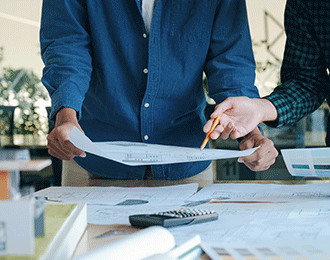 Zwei Personen besprechen Pläne eines Hauses